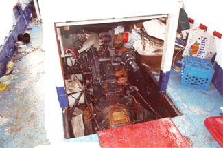 Photo 4 - Opening in main deck with no steel coaming in way of portable plywood panels of engine casing